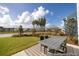 Spacious backyard with a patio dining set, lush lawn, and picturesque views of the pond at 1054 Marsh Harrier Dr # Cc3-15-5P, Ravenel, SC 29470