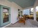 Inviting front porch features an aqua-colored door, comfortable seating, and a blue-painted ceiling at 1054 Marsh Harrier Dr # Cc3-15-5P, Ravenel, SC 29470