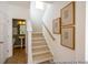 Elegant staircase with wooden banister, accented by decorative artwork and leading to the upper level at 1054 Marsh Harrier Dr # Cc3-15-5P, Ravenel, SC 29470