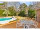 Relaxing backyard scene with a deck, patio table, pool, and mature trees at 1060 Yeamans Hall Rd, Hanahan, SC 29410