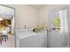 Functional laundry room with a washer and dryer, natural light, and convenient access to the backyard at 1060 Yeamans Hall Rd, Hanahan, SC 29410