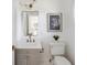 This powder room features gray cabinets, and modern gold fixtures with a white countertop and framed art at 118 Freeman St, Mount Pleasant, SC 29464