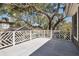 Large outdoor deck featuring white railings with mature trees and view at 118 Freeman St, Mount Pleasant, SC 29464