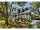 Stunning exterior view of a two-story home with gray siding, lush landscaping, and mature trees on a sunny day at 118 Freeman St, Mount Pleasant, SC 29464