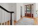 Bright foyer with hardwood floors, a wooden front door with glass panes, and staircase with dark wood banister at 118 Freeman St, Mount Pleasant, SC 29464