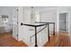 Hallway with hardwood floors and staircase with black and white railings at 118 Freeman St, Mount Pleasant, SC 29464