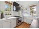 Kitchen features gas range and custom cabinets with marble countertops, a farmhouse style sink, and open shelves at 118 Freeman St, Mount Pleasant, SC 29464