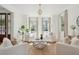 Bright and airy living room with white armchairs, decorative pillows, and views to the outside through large windows at 118 Freeman St, Mount Pleasant, SC 29464