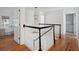 Bright staircase with wooden floors and black and white railing, open to another room at 118 Freeman St, Mount Pleasant, SC 29464