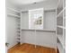Bright walk-in closet with window, wooden floors, and built-in shelving and rods at 118 Freeman St, Mount Pleasant, SC 29464