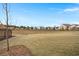 A large, grassy backyard with newly constructed homes in the background at 125 Leeward Landing, Summerville, SC 29486
