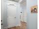 Hallway with hardwood flooring, white trim, and a convenient pantry access for easy storage at 125 Leeward Landing, Summerville, SC 29486