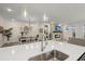 Open-concept kitchen island with stainless steel sink, dining area, and fireplace, creating a welcoming space at 125 Leeward Landing, Summerville, SC 29486