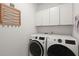 Well-equipped laundry area with modern washer and dryer, and overhead cabinets for ample storage at 125 Leeward Landing, Summerville, SC 29486