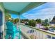Balcony view with aqua chair overlooking palm trees, parking area and pier at 1300 Ocean Blvd # 232, Isle of Palms, SC 29451