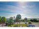 Elevated view of palm trees overlooking parking and the pier with sunny skies and ocean views at 1300 Ocean Blvd # 232, Isle of Palms, SC 29451