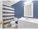 Bright bathroom with white vanity, sink, a striped shower curtain and matching mirror at 1310 Pilsdon Crest, Mount Pleasant, SC 29464