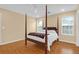 Bright bedroom boasts a four-poster bed, two windows, and neutral walls for a peaceful retreat at 1310 Pilsdon Crest, Mount Pleasant, SC 29464