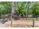 Community playground with black fence, mature trees, and play equipment at 1310 Pilsdon Crest, Mount Pleasant, SC 29464