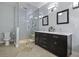 Bathroom featuring dual vanities, tile flooring, a glass-enclosed shower, and modern lighting at 1365 Whippoorwill Farm Rd, Johns Island, SC 29455