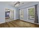 Bedroom with two windows, hardwood floors, soft blue walls and a view to an adjacent room at 1365 Whippoorwill Farm Rd, Johns Island, SC 29455