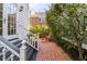 Charming backyard with brick pathway, lush foliage, and cozy seating, perfect for outdoor relaxation at 15 Menotti St, Charleston, SC 29401