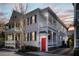 Charming two-story home at dusk with white siding, wood shutters, and an inviting orange front door at 15 Menotti St, Charleston, SC 29401