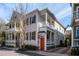 Charming two-story home with white siding, wood shutters, and an inviting orange front door at 15 Menotti St, Charleston, SC 29401