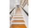 Elegant staircase with wooden steps, white risers, and dark railings provides access to upper floors at 15 Menotti St, Charleston, SC 29401