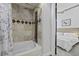 Bathroom featuring a tub with shower, tiled walls, and a view into the bedroom at 150 Bee St # 312, Charleston, SC 29401