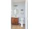 Stylish half bathroom with geometric wallpaper, a round mirror, and a modern vanity at 1749 Towne St, Johns Island, SC 29455