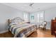 Bedroom with hardwood floors, ceiling fan, two windows with blinds, and an armchair at 1962 Bellona St, Charleston, SC 29492