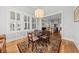 Bright dining area with shuttered windows, a chandelier, and hardwood floors, open to the kitchen at 1962 Bellona St, Charleston, SC 29492