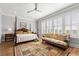 Serene main bedroom with a four-poster bed, sitting area, and a ceiling fan at 1962 Bellona St, Charleston, SC 29492