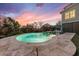 Inviting pool with travertine tile and lounge chairs beneath a vibrant sunset sky at 1962 Bellona St, Charleston, SC 29492