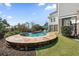 Backyard pool with blue lounge chairs and blue patio umbrella and view of the house at 1962 Bellona St, Charleston, SC 29492