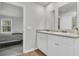 Bright bathroom featuring a double sink vanity and an adjacent bedroom view with a queen-size bed at 205 Cozy Brook Ct, Summerville, SC 29486