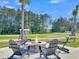 A cozy outdoor fire pit surrounded by Adirondack chairs, perfect for gathering and enjoying the scenery at 205 Cozy Brook Ct, Summerville, SC 29486