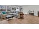Spacious living room with large windows, wood floors, and a comfortable grey sectional sofa at 205 Cozy Brook Ct, Summerville, SC 29486