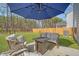 Outdoor living space with a cozy seating area around a fire pit under a large blue patio umbrella at 215 Camellia Bloom Dr, Moncks Corner, SC 29461