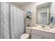 Bathroom showcasing a shower with patterned curtain, toilet, vanity, and decorative shelves at 215 Camellia Bloom Dr, Moncks Corner, SC 29461