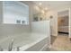 Bright bathroom with a large window, featuring a luxurious soaking tub for ultimate relaxation at 215 Camellia Bloom Dr, Moncks Corner, SC 29461