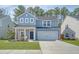 Charming two-story home with a well-manicured lawn and inviting front porch at 215 Camellia Bloom Dr, Moncks Corner, SC 29461