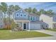 Charming two-story home with a manicured lawn, inviting porch, and attached garage, showcasing curb appeal at 215 Camellia Bloom Dr, Moncks Corner, SC 29461