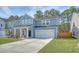 Attractive two-story home with a well-kept lawn, covered porch, and attached garage, exhibiting modern design at 215 Camellia Bloom Dr, Moncks Corner, SC 29461