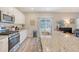 Updated kitchen with modern appliances, white cabinetry, and a view of the backyard at 215 Camellia Bloom Dr, Moncks Corner, SC 29461