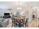 Open concept living room with hardwood floors, dining area, and comfortable gray sofas at 215 Camellia Bloom Dr, Moncks Corner, SC 29461
