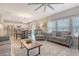 Bright living room with a ceiling fan, hardwood floors, and large windows with natural light at 215 Camellia Bloom Dr, Moncks Corner, SC 29461