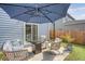 Inviting patio with stylish seating, a modern fire pit, and a large umbrella for relaxing outdoors at 215 Camellia Bloom Dr, Moncks Corner, SC 29461
