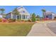 Community clubhouse with a welcoming front porch, surrounded by lush landscaping and a paved walkway at 215 Shortmarsh St, Summerville, SC 29486